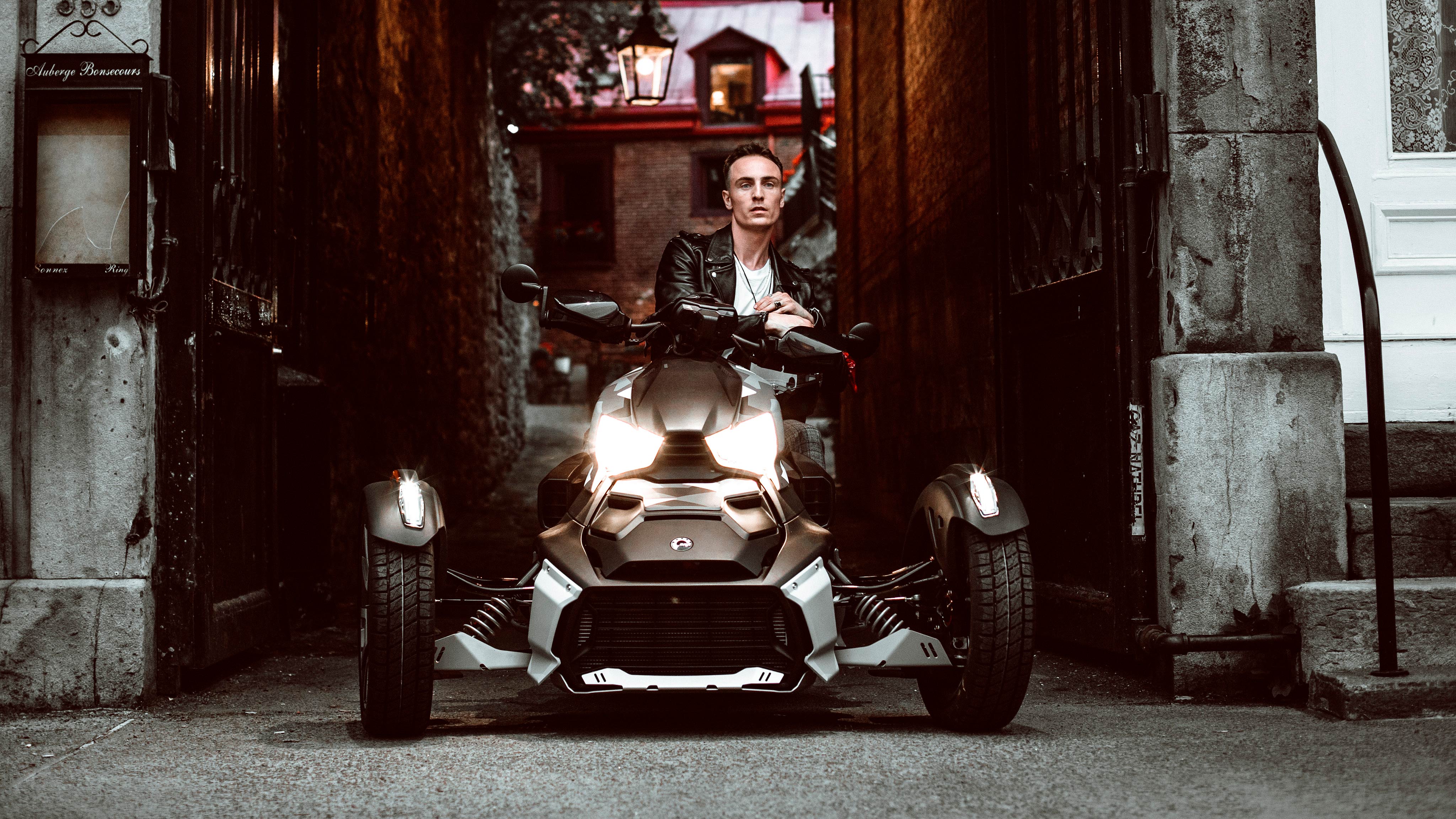 Man in alley sitting on a Can-Am Ryker vehicle with liquid titanium panels