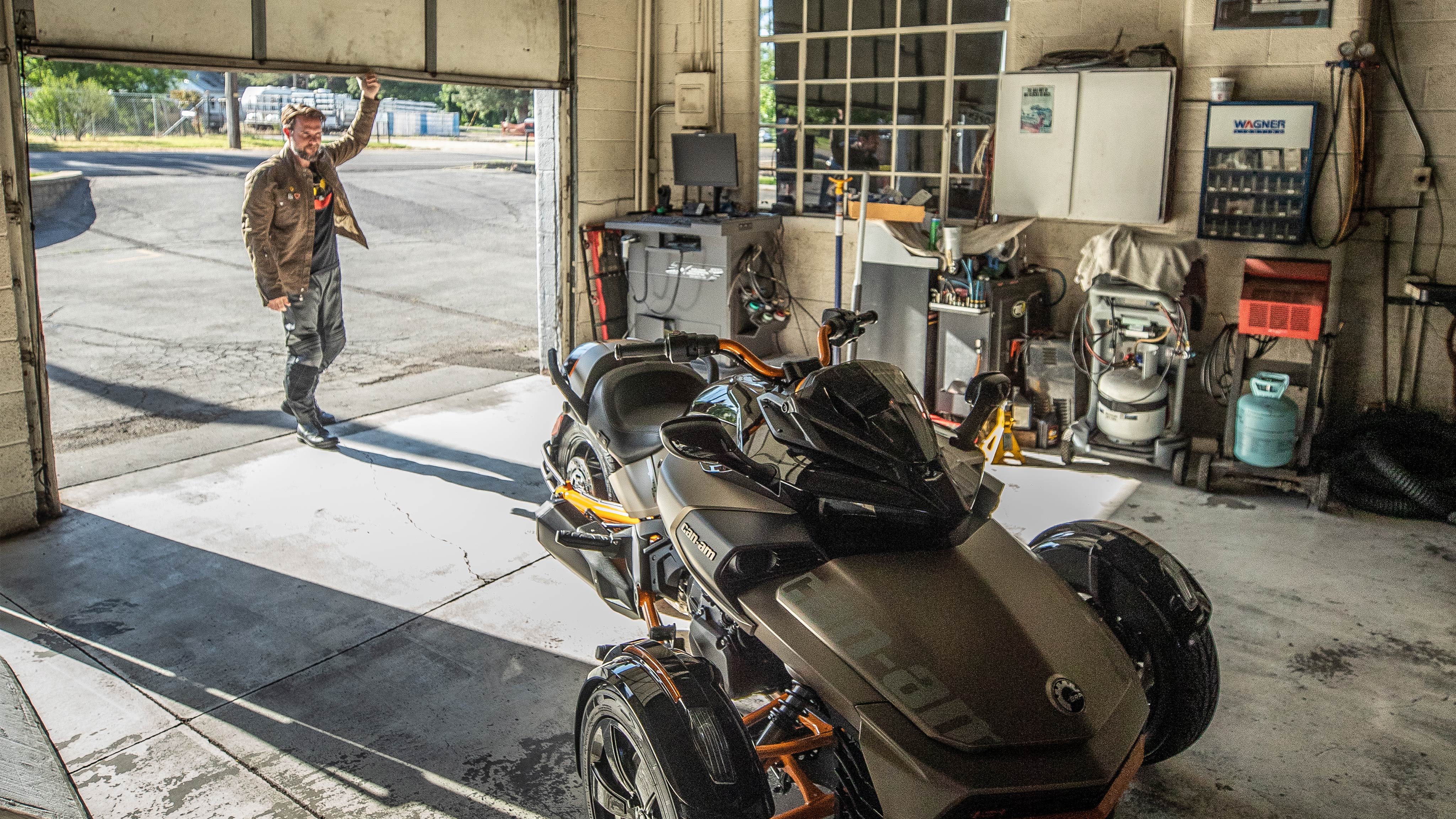 Can-Am Spyder F3が駐車されたガレージのドアを開ける男性