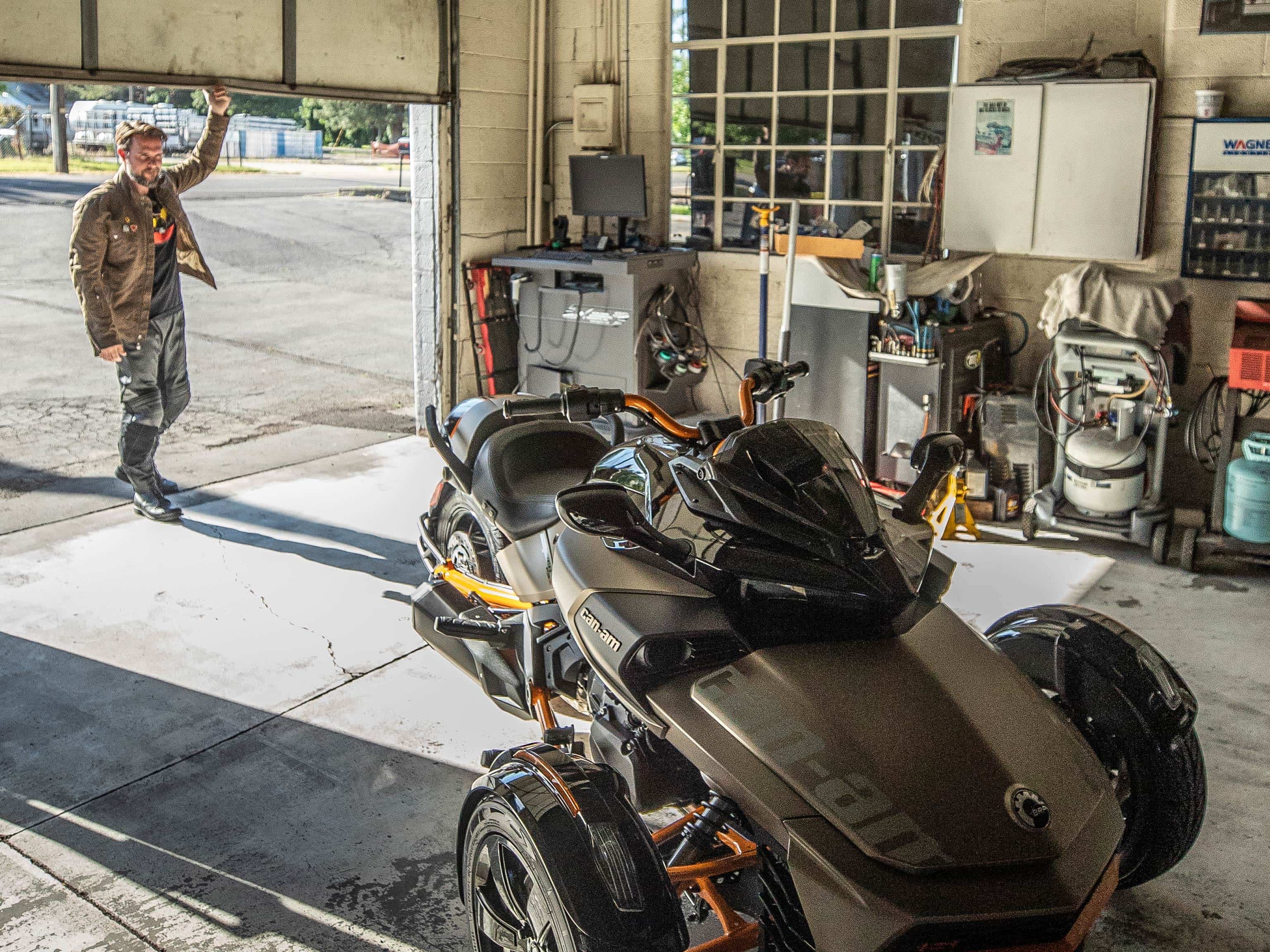 Man opening his garage to maintain his Can-Am Spyder.
