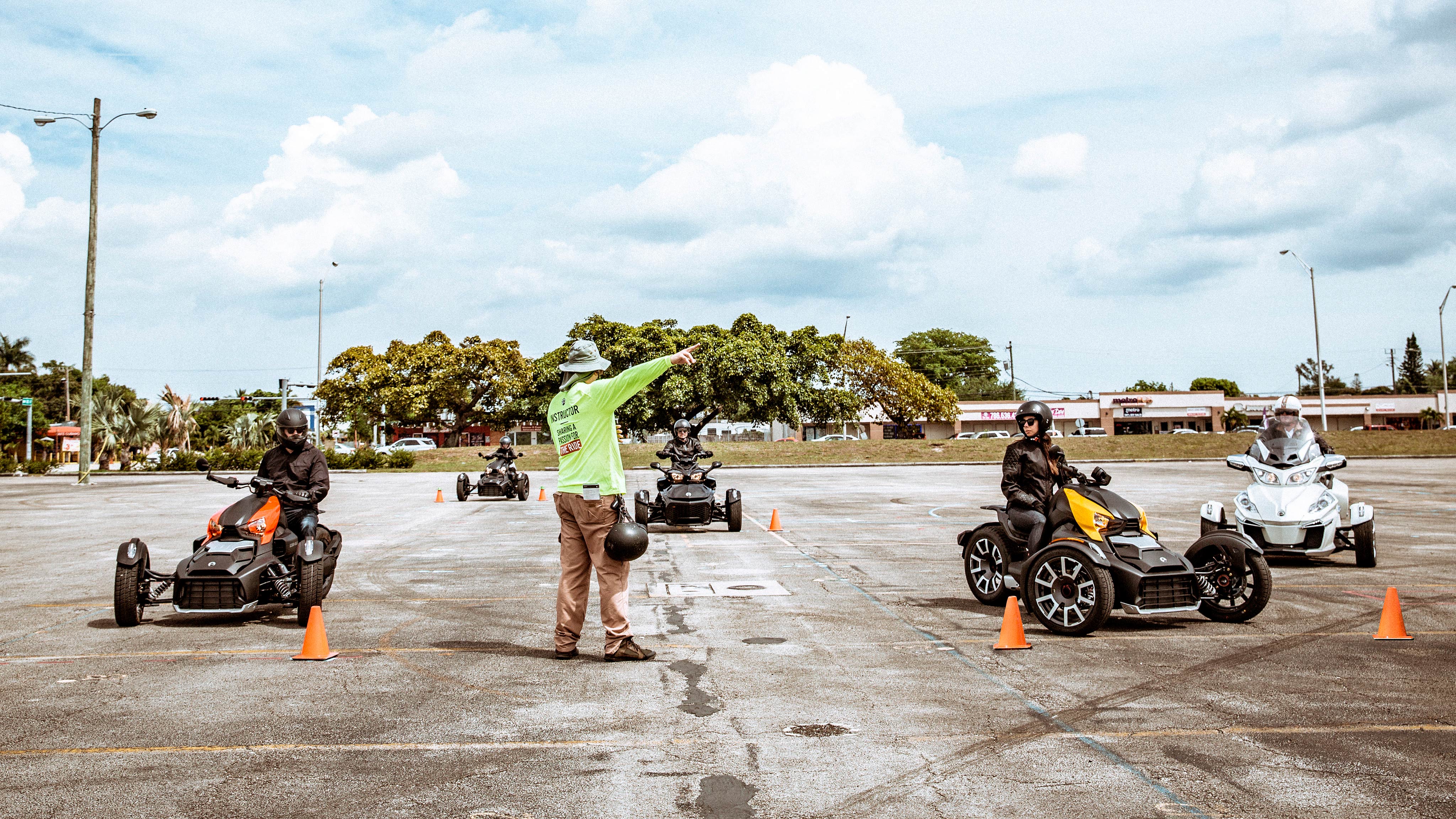 Estudiantes del programa de educación para pilotos aprendiendo a conducir vehículos Can-Am Ryker de 3 ruedas con su instructor