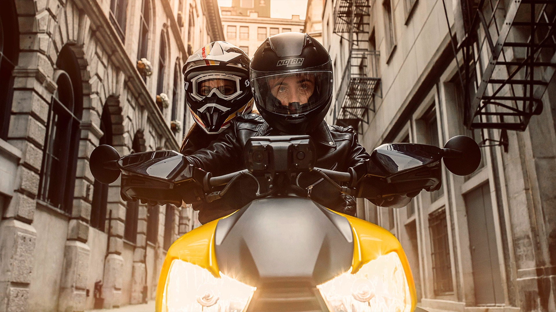 Two people on a Can-Am Ryker in the city front close-up view