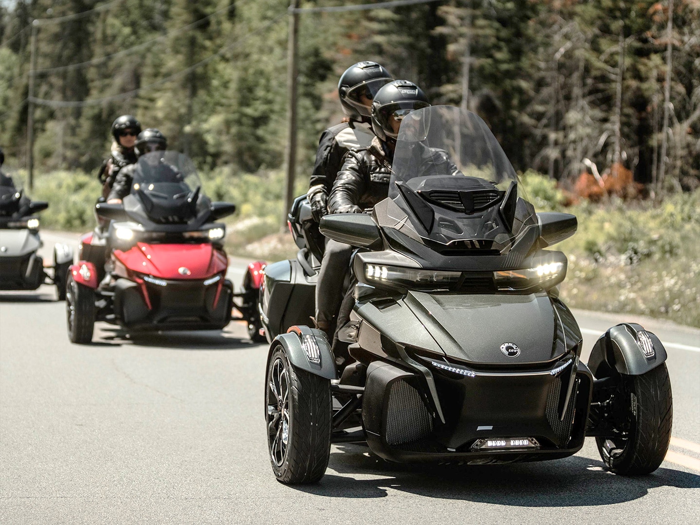 Riders with their Can-am three-wheel motorcycle