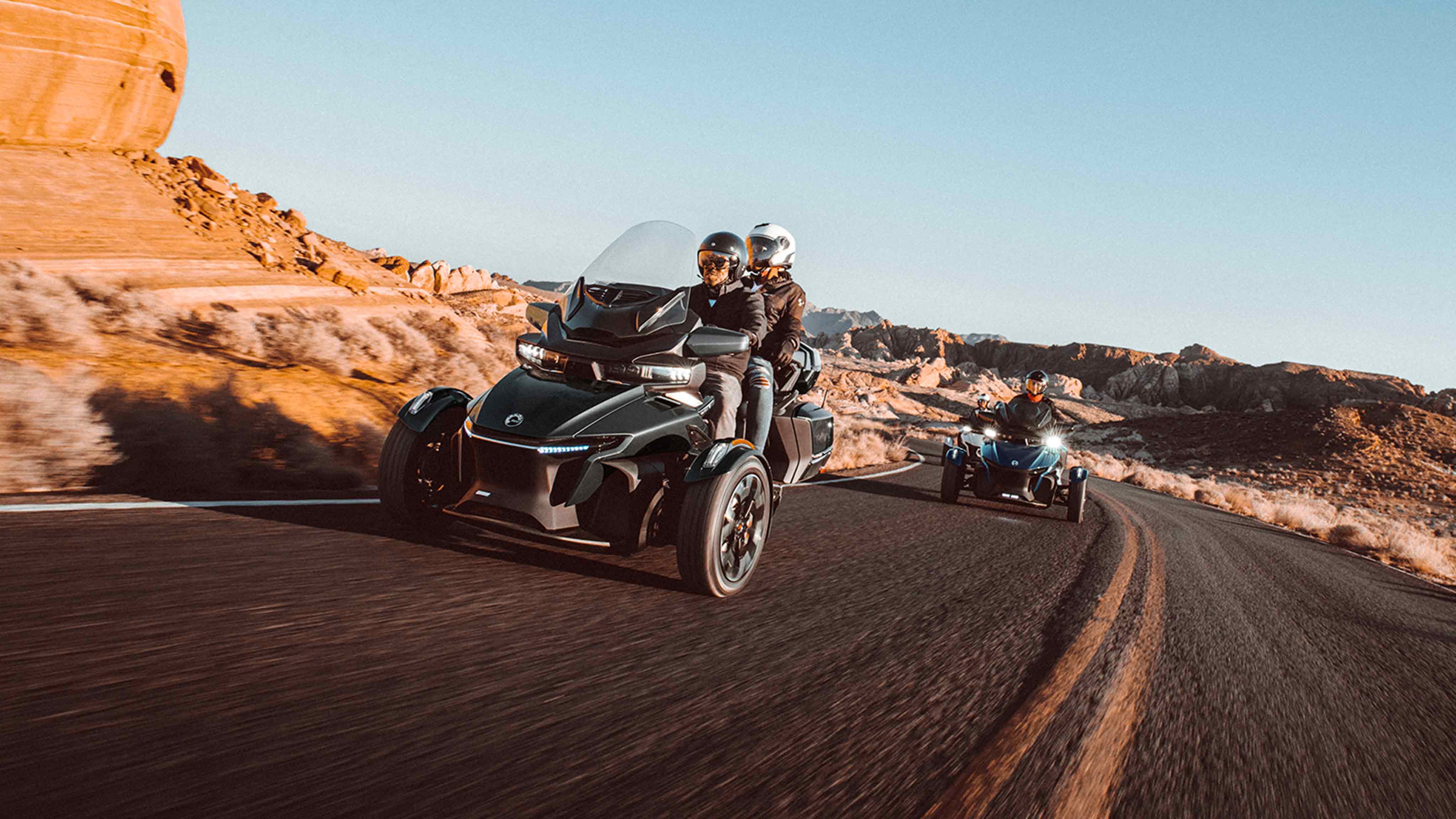 Two Can-Am Spyder vehicles on a roadway