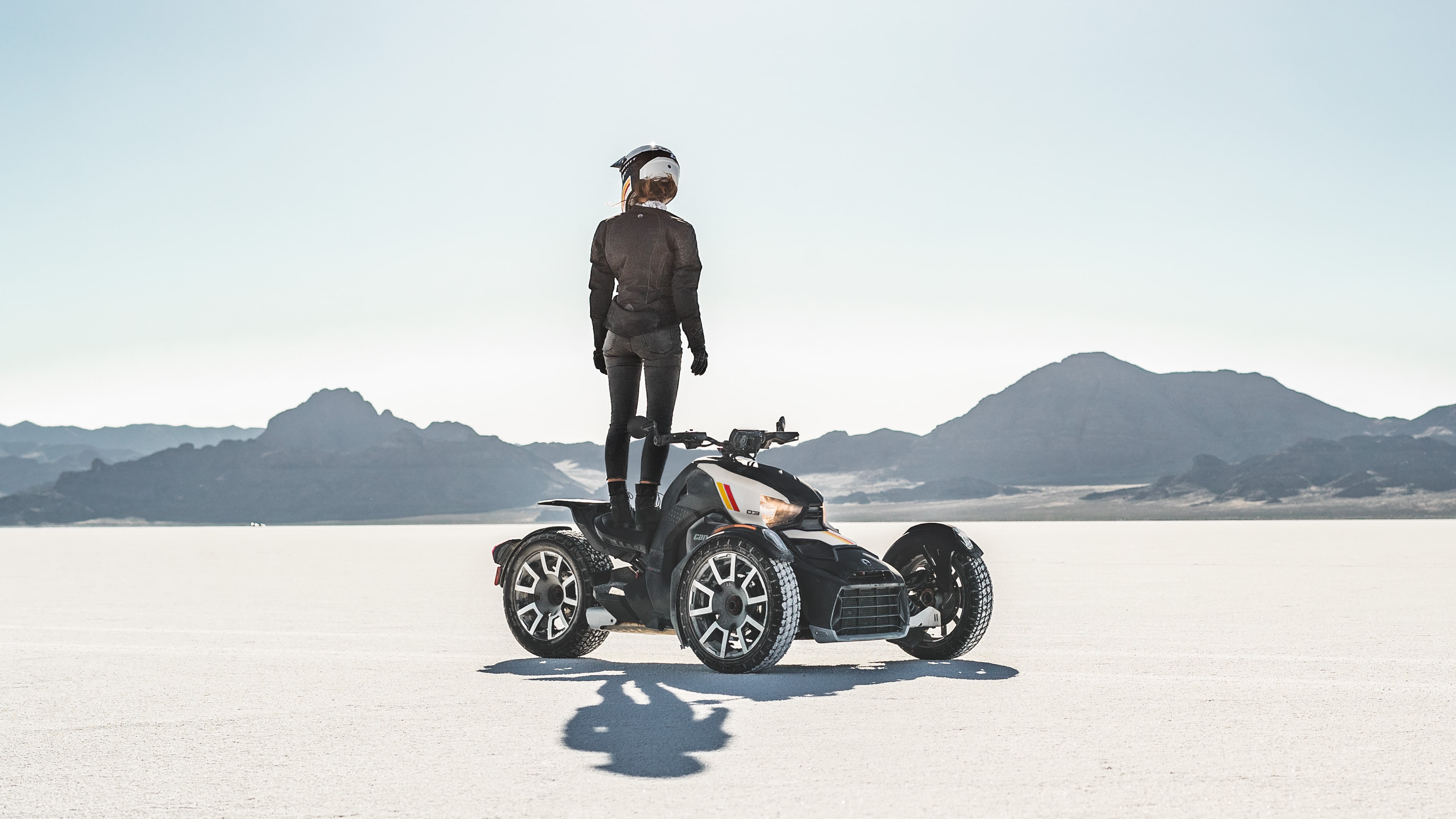 A rider standing on the seat of their Can-Am On-Road vehicle