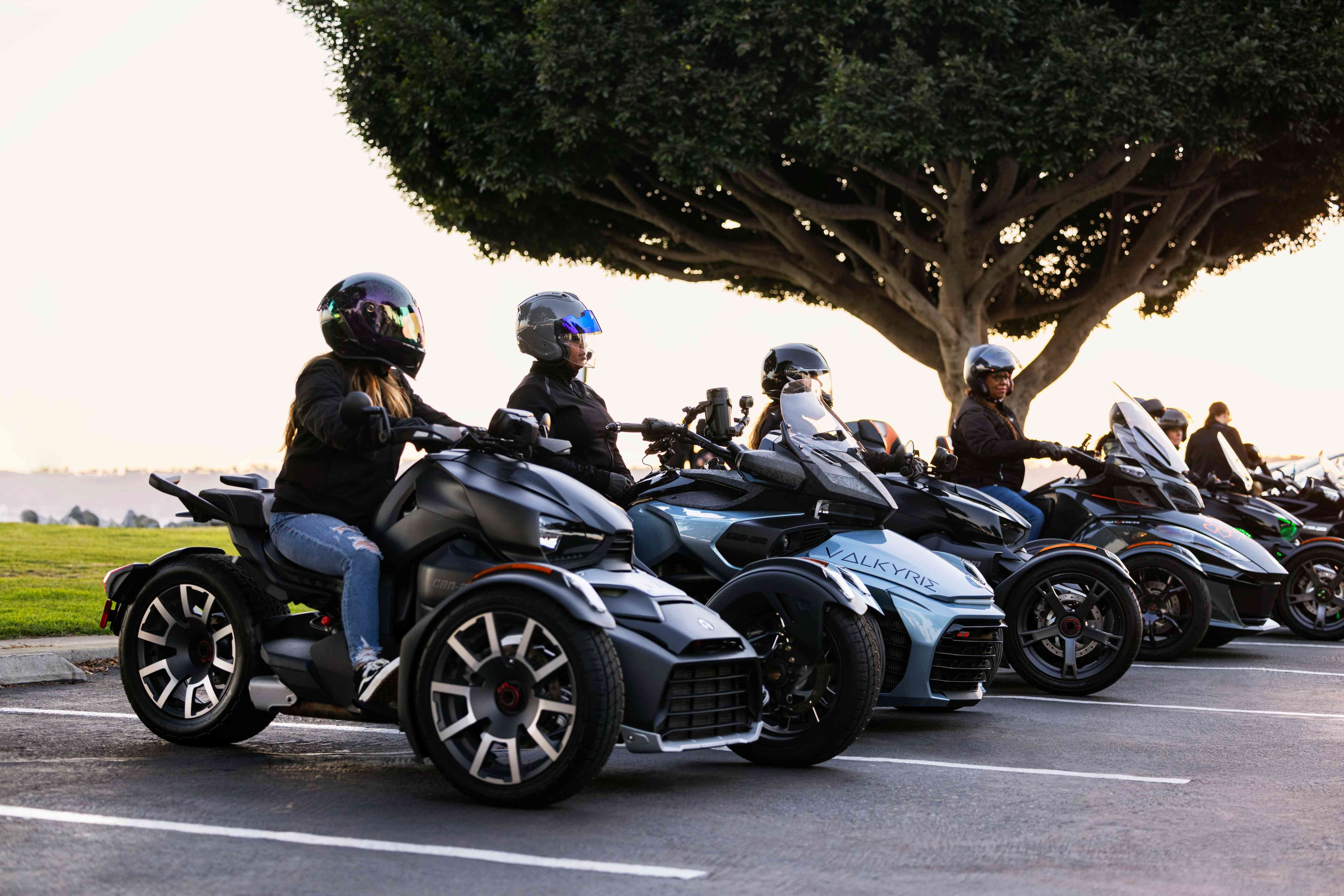 A group of women riders talking near a Can-Am vehicle