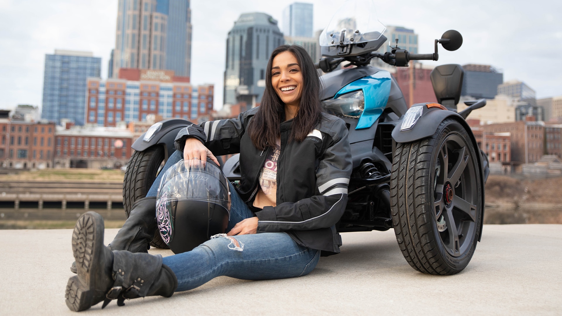 Can-Am On-Road Ambassador Julana Dizon sitting in front of her 3-wheel motorcycle