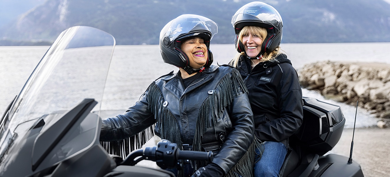 Two smiling women on a Can-Am Spyder
