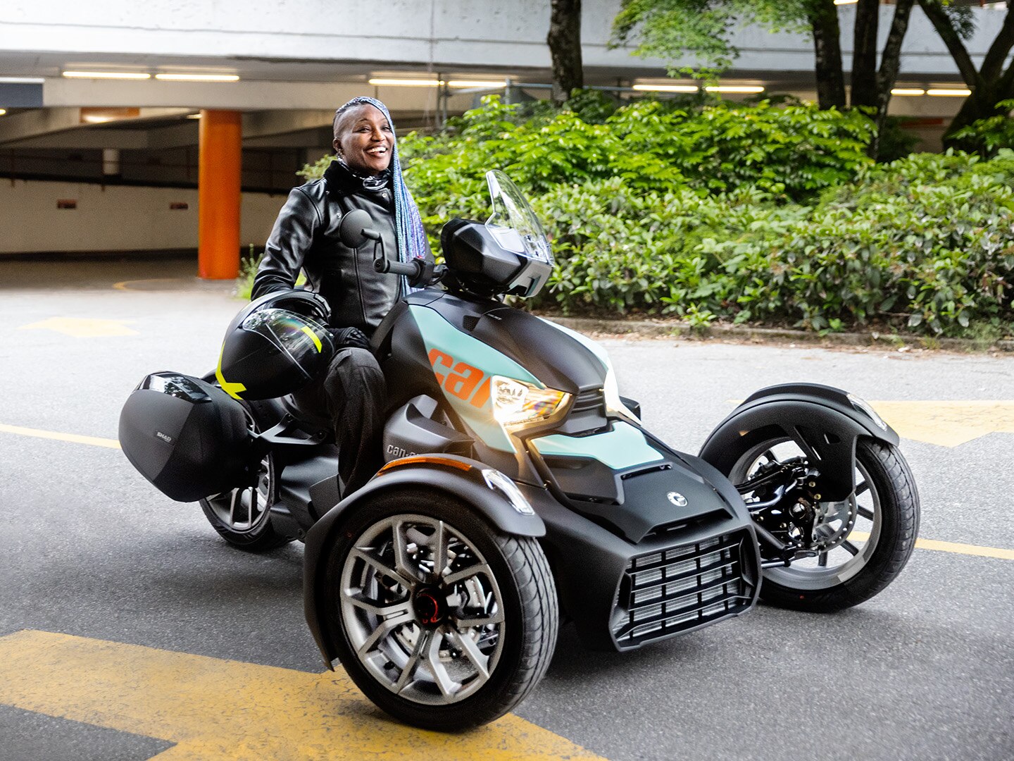 Woman posing with her Can-Am Ryker Sport 3-wheel motorcycle