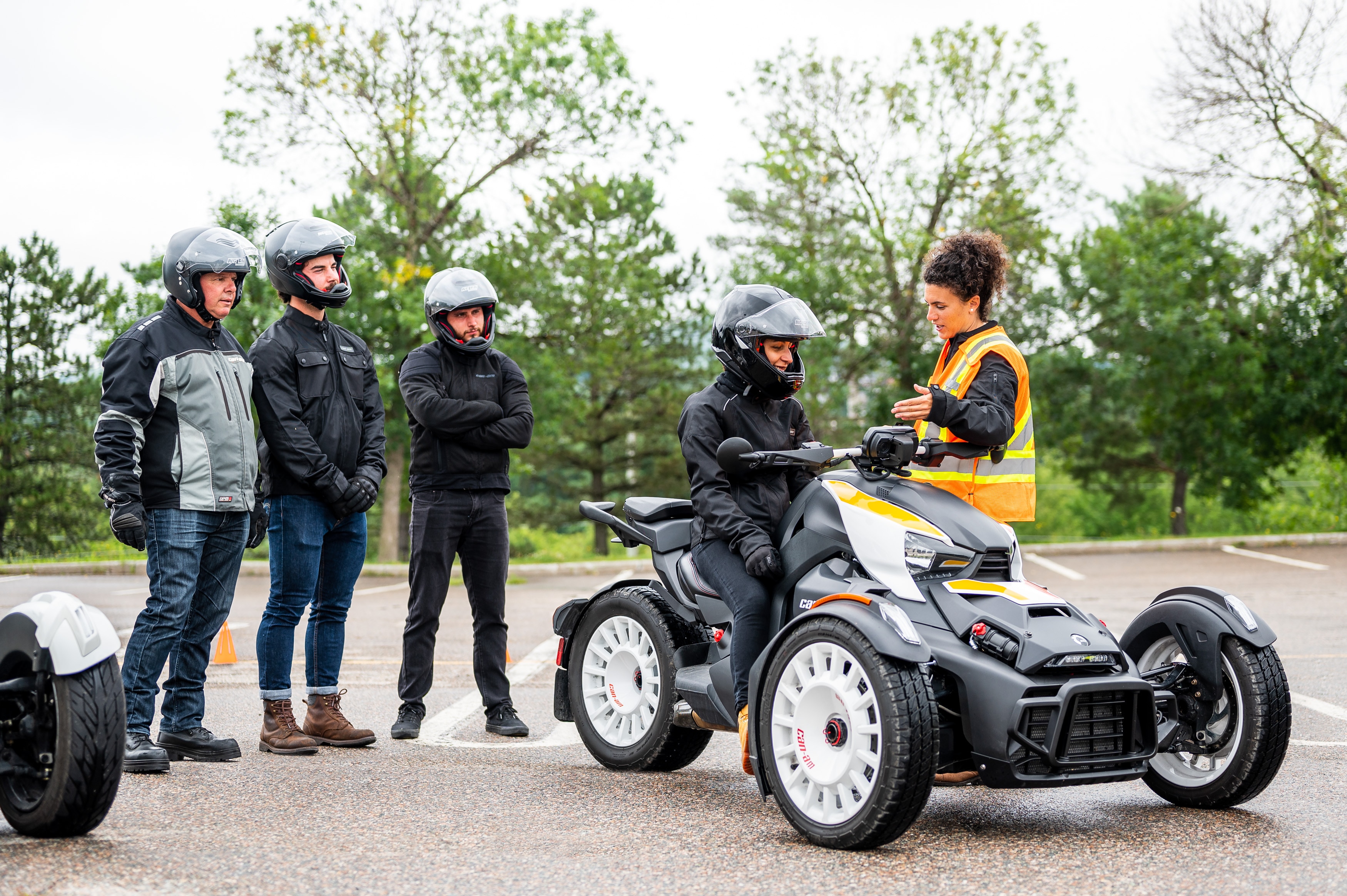 Female instructor explaining the Can-Am Ryker to a group of riders.