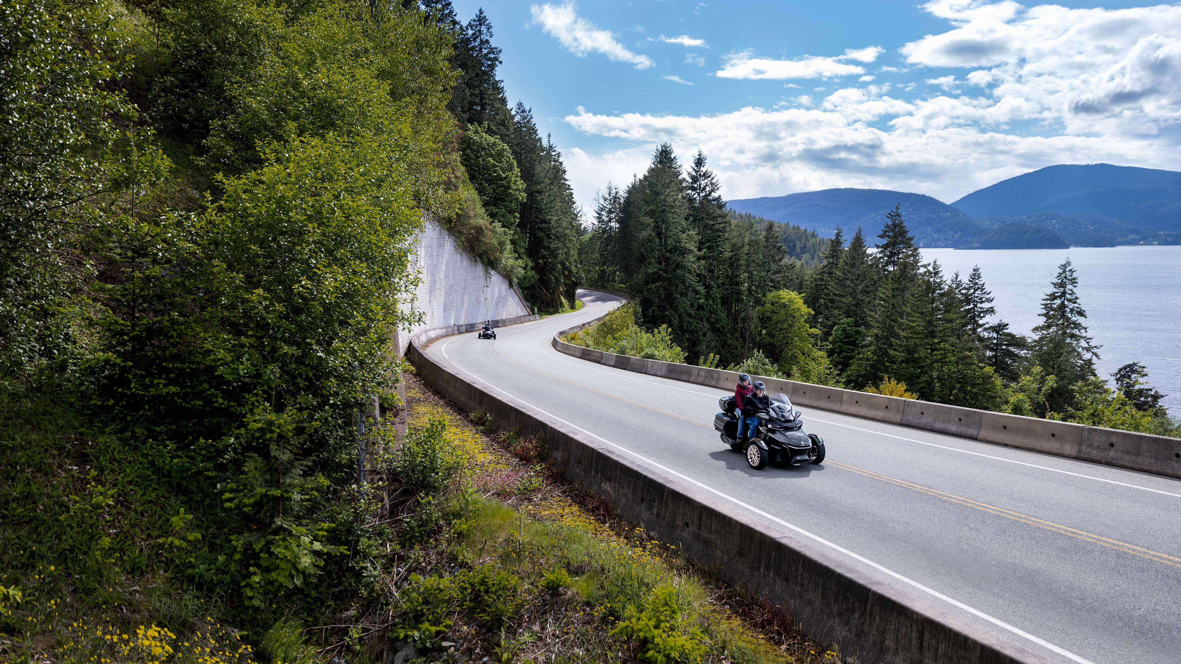 Two drivers riding a 2023 Can-Am Spyder RT on a scenic road