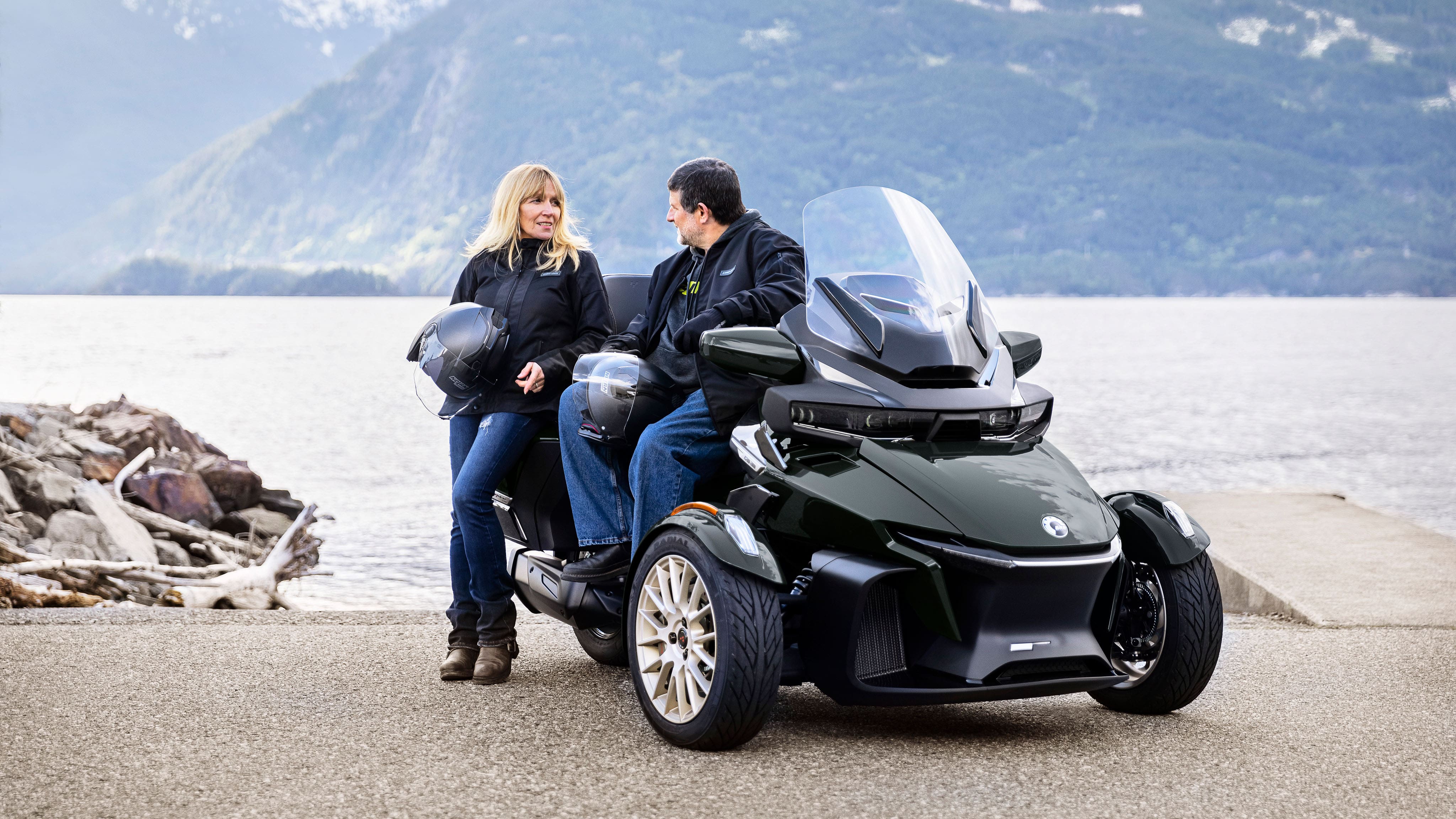 Couple sitting on a Can-Am Spyder Sea-to-Sky at the lake side