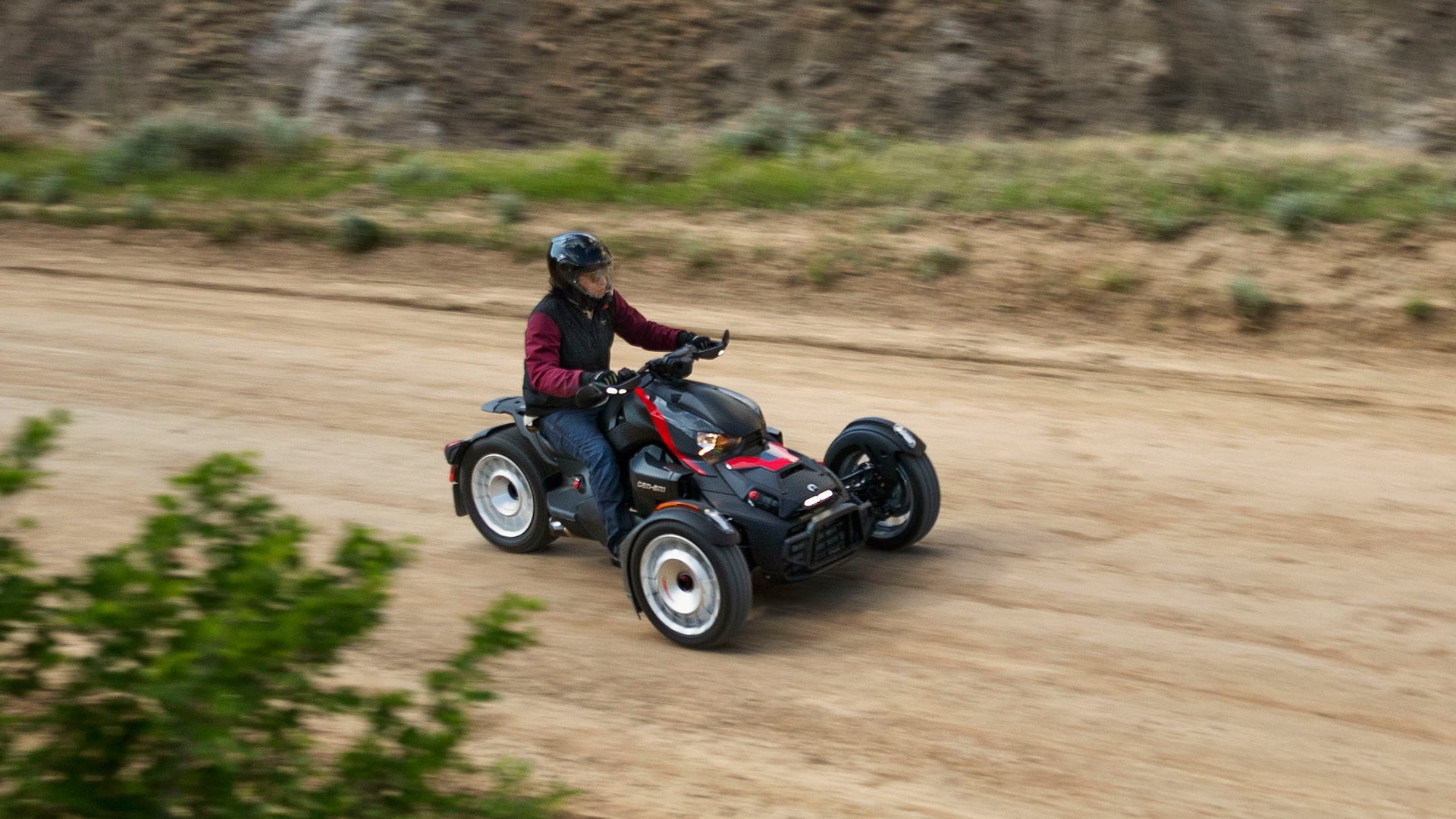 Can-Am Ryker 3-wheel motorcycle riding on a dirt road