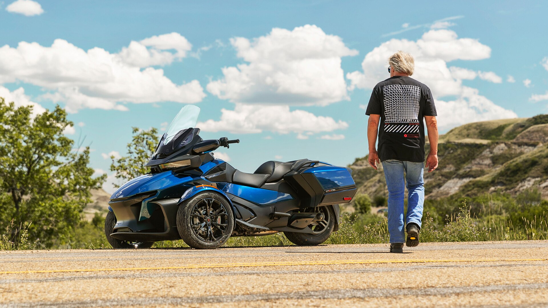 Man walking to his Can-Am Spyder RT 3-wheel motorcycle